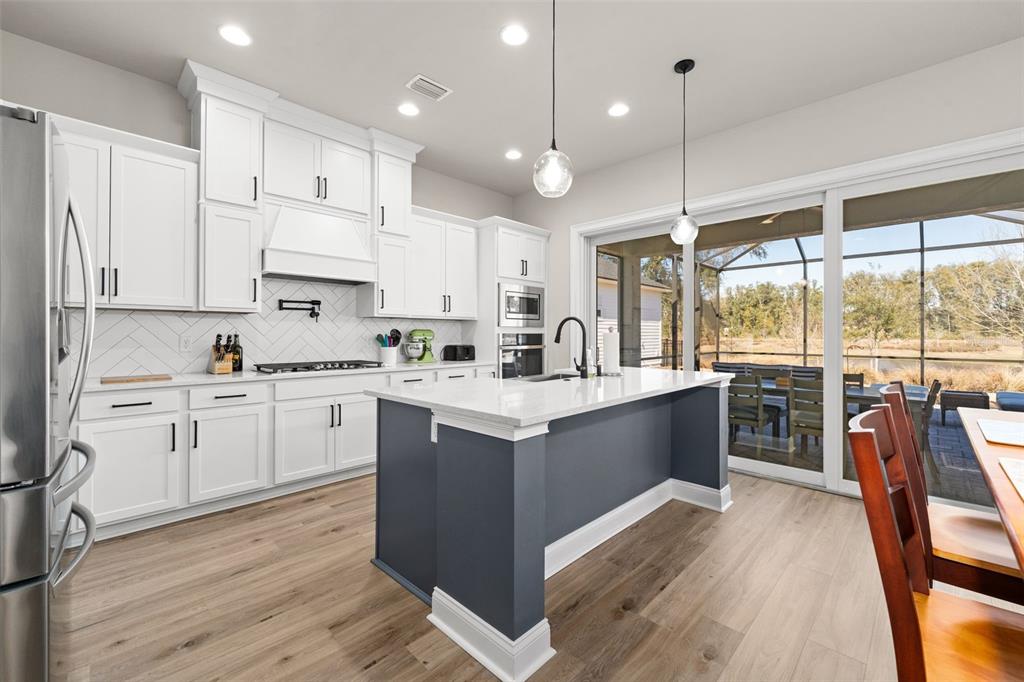 10778 Southwest 34th Road Gainesville, FL 32608 - Photo 15 of 62 a kitchen with kitchen island granite countertop a stove a sink a center island and a refrigerator