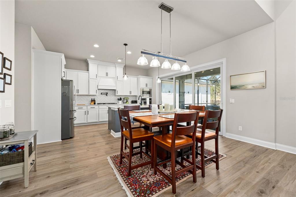 10778 Southwest 34th Road Gainesville, FL 32608 - Photo 18 of 62 a view of a dining room and livingroom with furniture wooden floor a chandelier