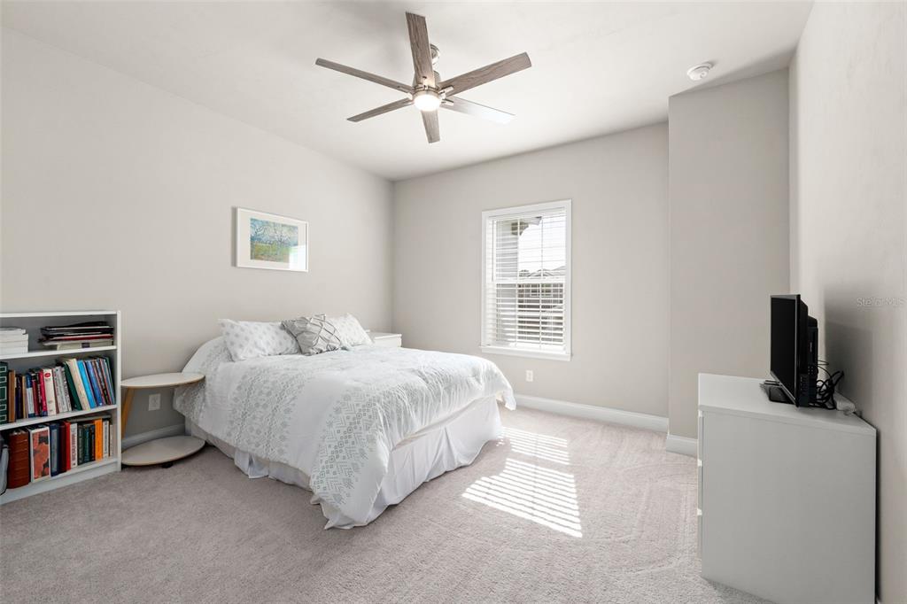 10778 Southwest 34th Road Gainesville, FL 32608 - Photo 35 of 62 a spacious bedroom with a bed and a book shelf