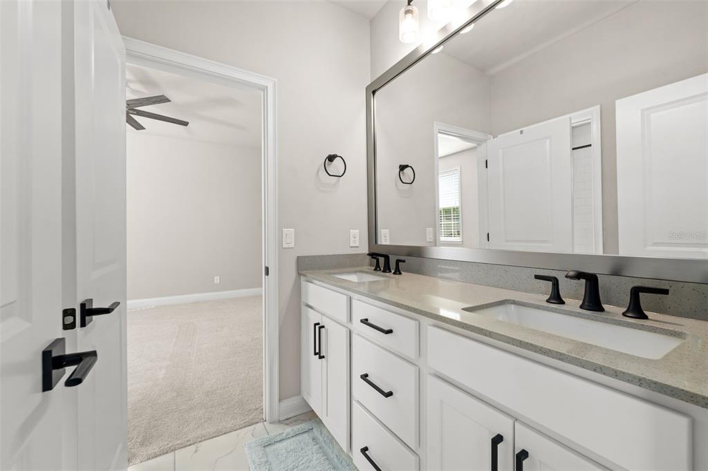 10778 Southwest 34th Road Gainesville, FL 32608 - Photo 40 of 62 a bathroom with a double vanity sink and mirror