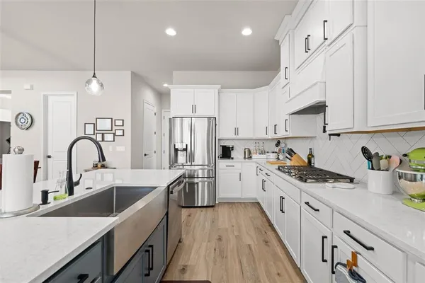 a view of a dining room and livingroom with furniture wooden floor a chandelier