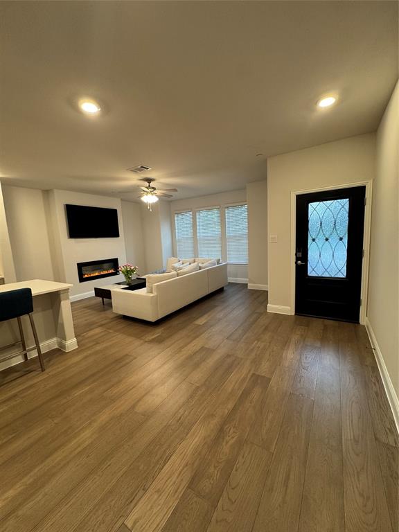 7849 Sunset Boulevard Rowlett, TX 75088 - Photo 2 of 19 Open concept living area featuring wood flooring, recessed lighting, and an electric fireplace