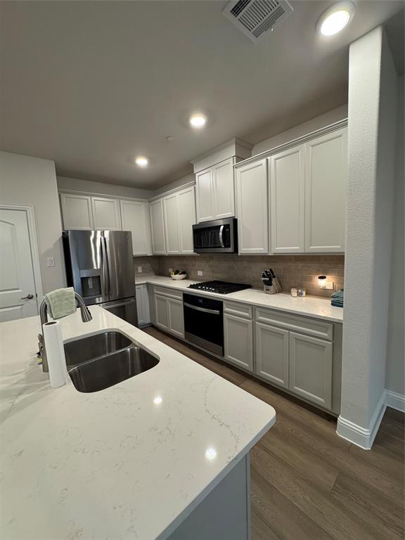 7849 Sunset Boulevard Rowlett, TX 75088 - Photo 5 of 19 The kitchen features light-colored cabinetry, stainless steel appliances, a double basin sink, and ample countertop space