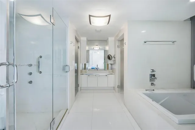 a bathroom with a bathtub a shower a sink and mirror