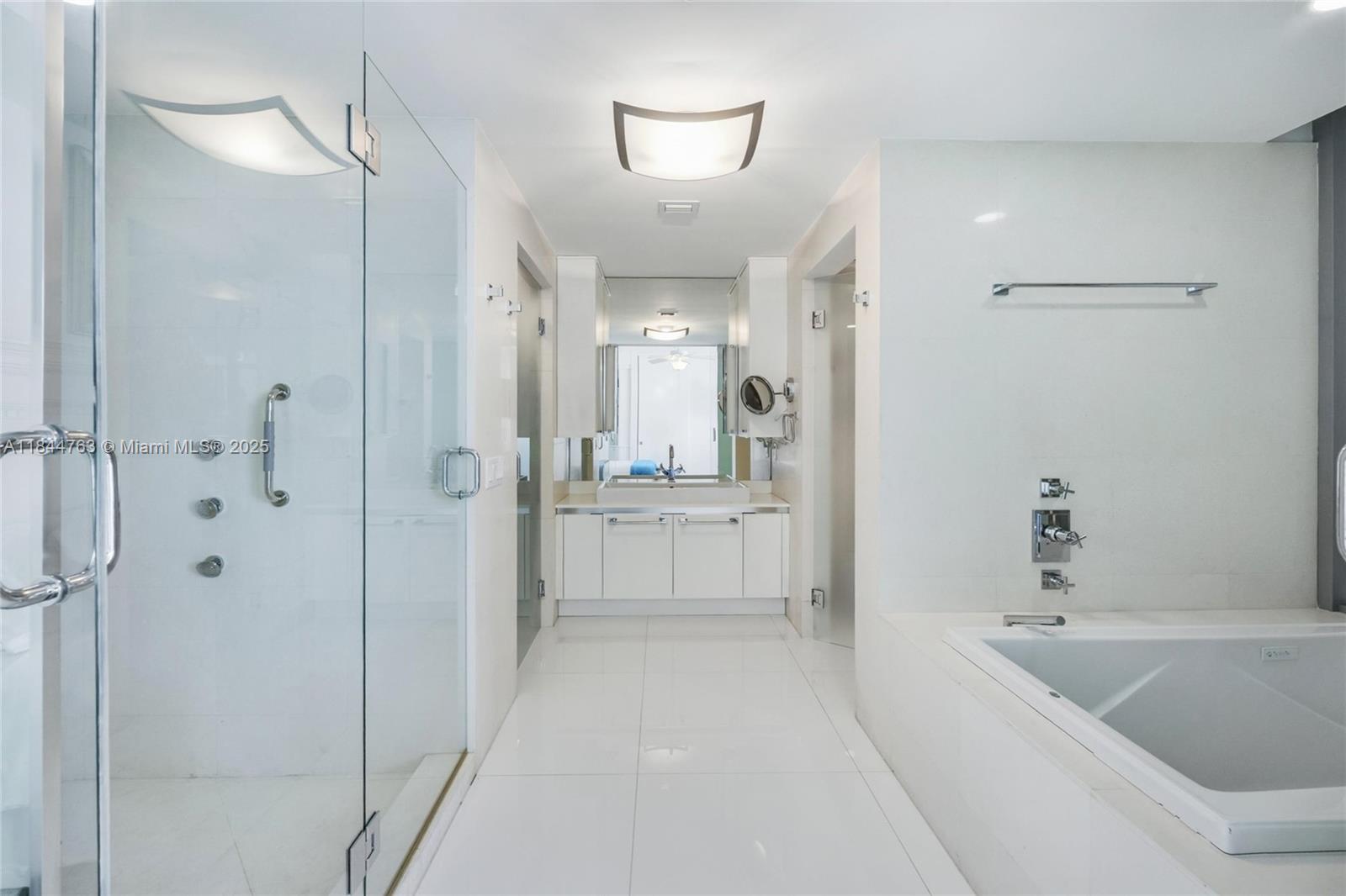3737 Collins Avenue, Unit S801 Miami Beach, FL 33140 - Photo 15 of 24 a bathroom with a bathtub a shower a sink and mirror