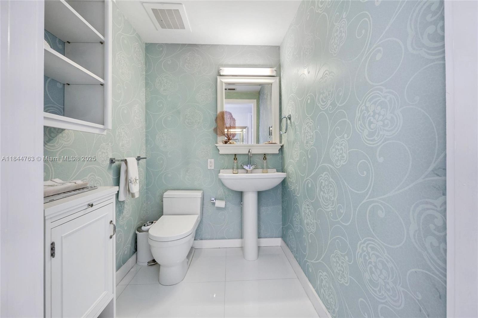 3737 Collins Avenue, Unit S801 Miami Beach, FL 33140 - Photo 17 of 24 a bathroom with a toilet sink and mirror