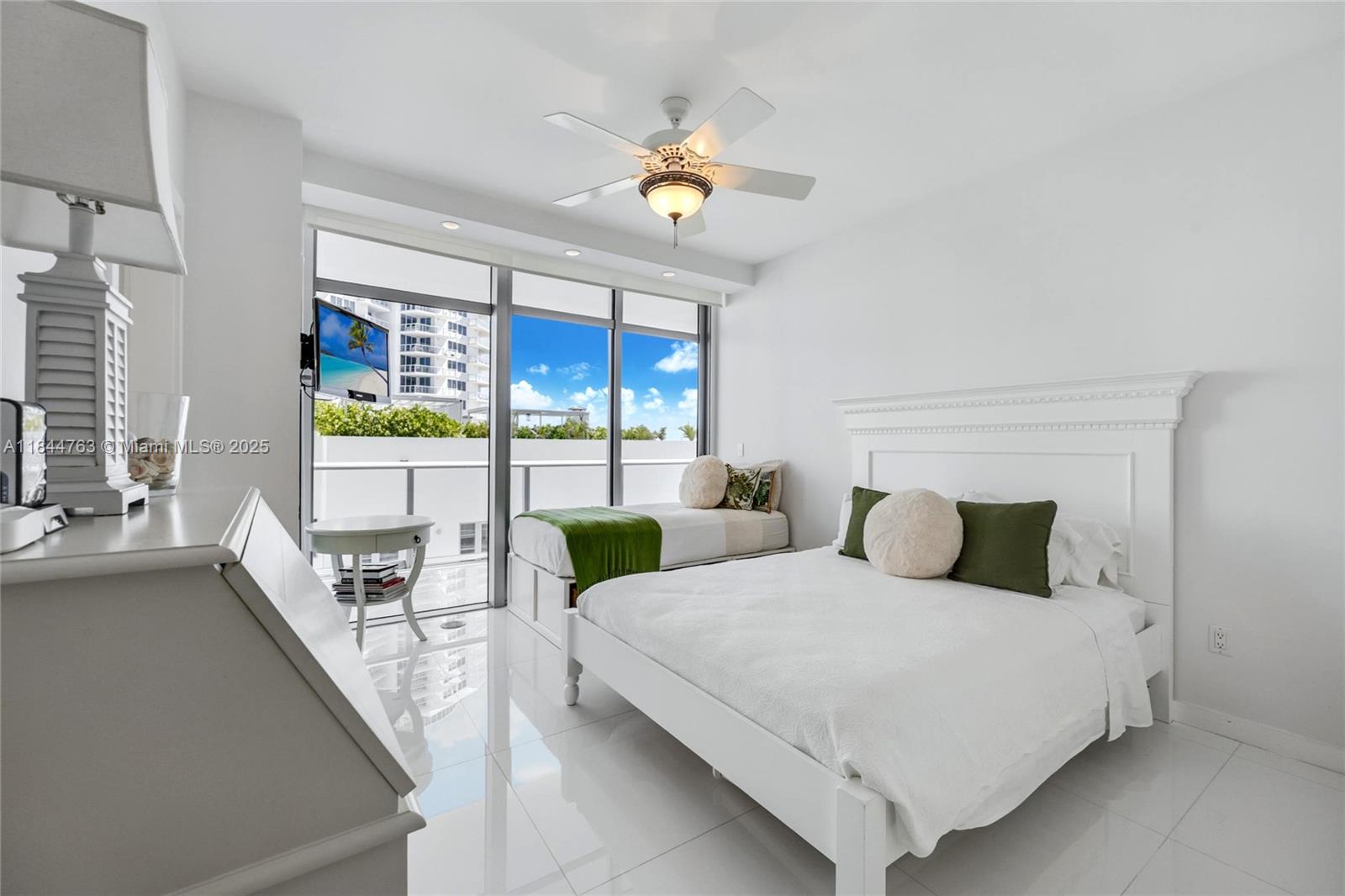 3737 Collins Avenue, Unit S801 Miami Beach, FL 33140 - Photo 19 of 24 a bedroom with a large bed and a chandelier