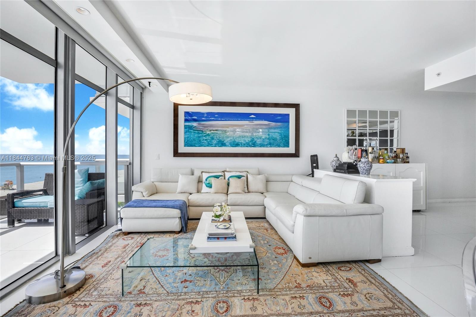 3737 Collins Avenue, Unit S801 Miami Beach, FL 33140 - Photo 5 of 24 a living room with furniture and a flat screen tv