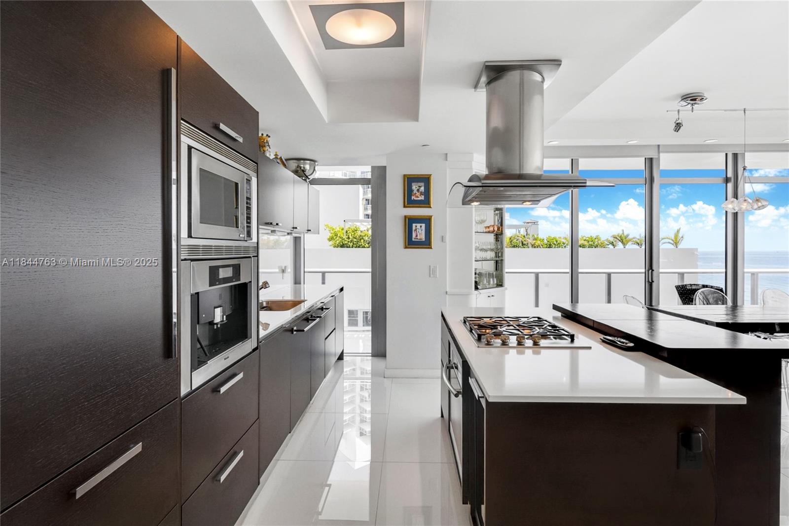 3737 Collins Avenue, Unit S801 Miami Beach, FL 33140 - Photo 10 of 24 a kitchen with stainless steel appliances granite countertop a sink a stove and a refrigerator