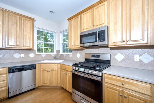 a view of an empty room with a fireplace and a window