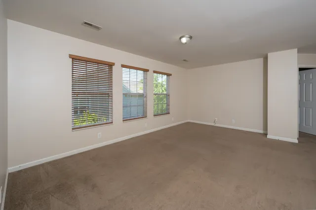 a spacious bathroom with a granite countertop sink a toilet and a mirror
