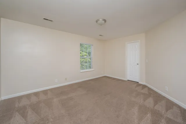 an empty room with closet area and a window
