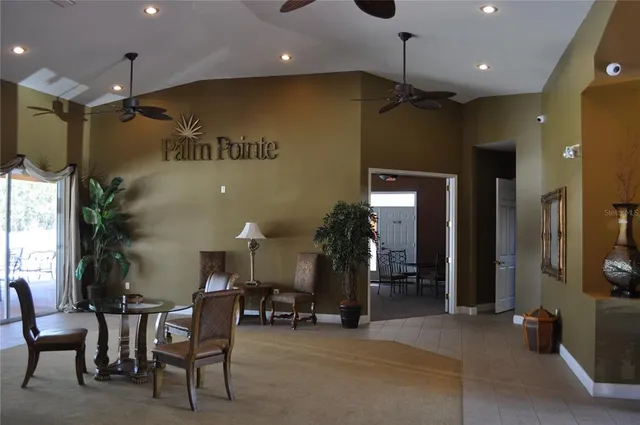 a living room with furniture pool table and a painting on the wall