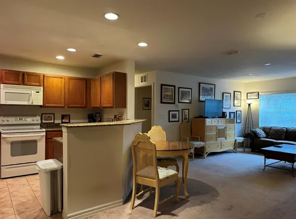 a kitchen with stainless steel appliances granite countertop a refrigerator and a stove top oven with wooden floor