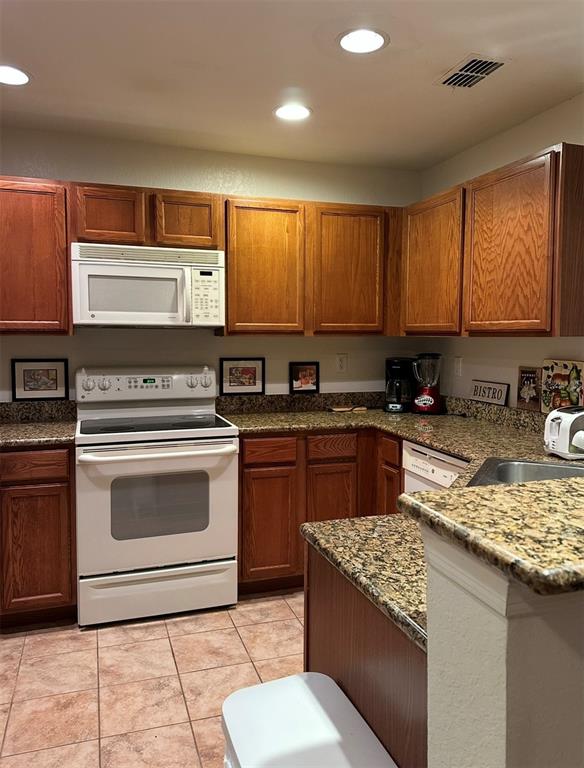 4600 East Moody Boulevard, Unit 3J Bunnell, FL 32110 - Photo 3 of 20 a kitchen with stainless steel appliances granite countertop a stove a sink and a microwave