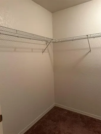 a bedroom with a bed a mirror on dresser and a large mirror