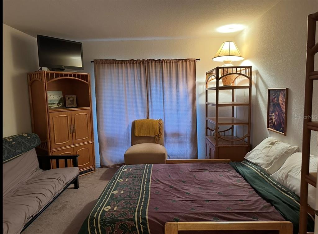 4600 East Moody Boulevard, Unit 3J Bunnell, FL 32110 - Photo 10 of 20 a bedroom with a bed a mirror on dresser and a large mirror