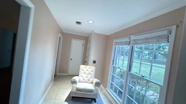 a living room with furniture and a floor to ceiling window