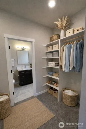 a view of walk in closet with clothes and shoes