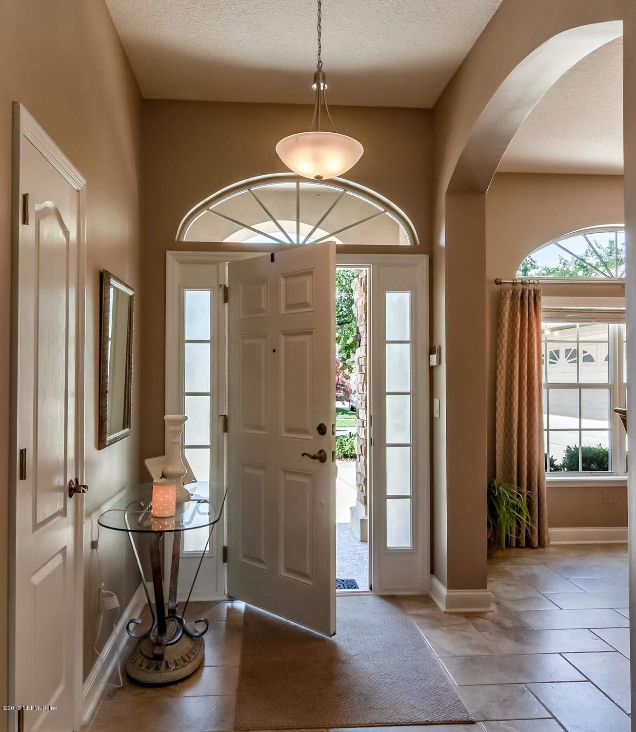 1152 Sandlake Road St. Augustine, FL 32092 - Photo 13 of 46 a view of a hallway with wooden floor and a chandelier