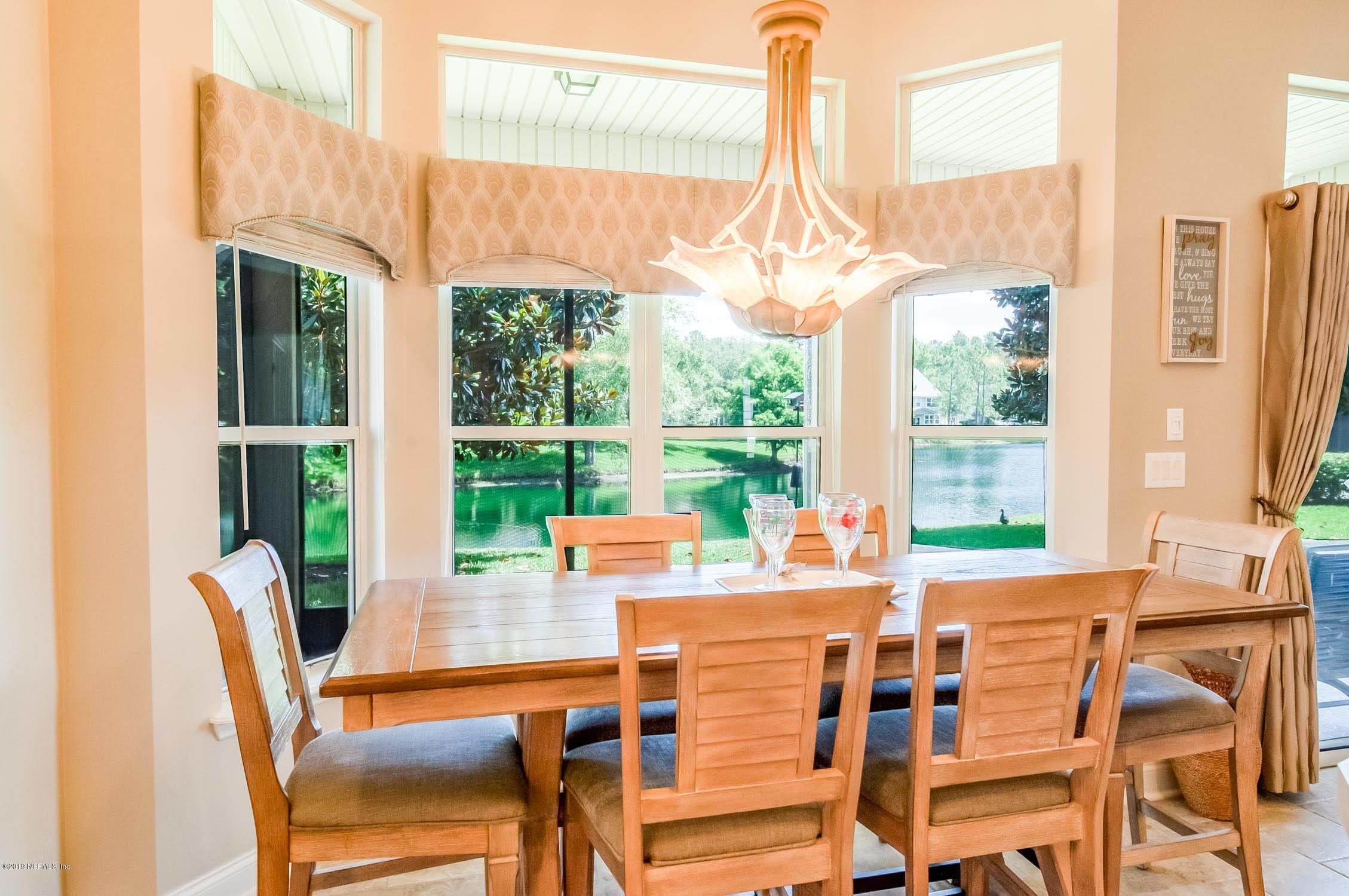 1152 Sandlake Road St. Augustine, FL 32092 - Photo 9 of 46 a view of a dining room with furniture large windows and wooden floor