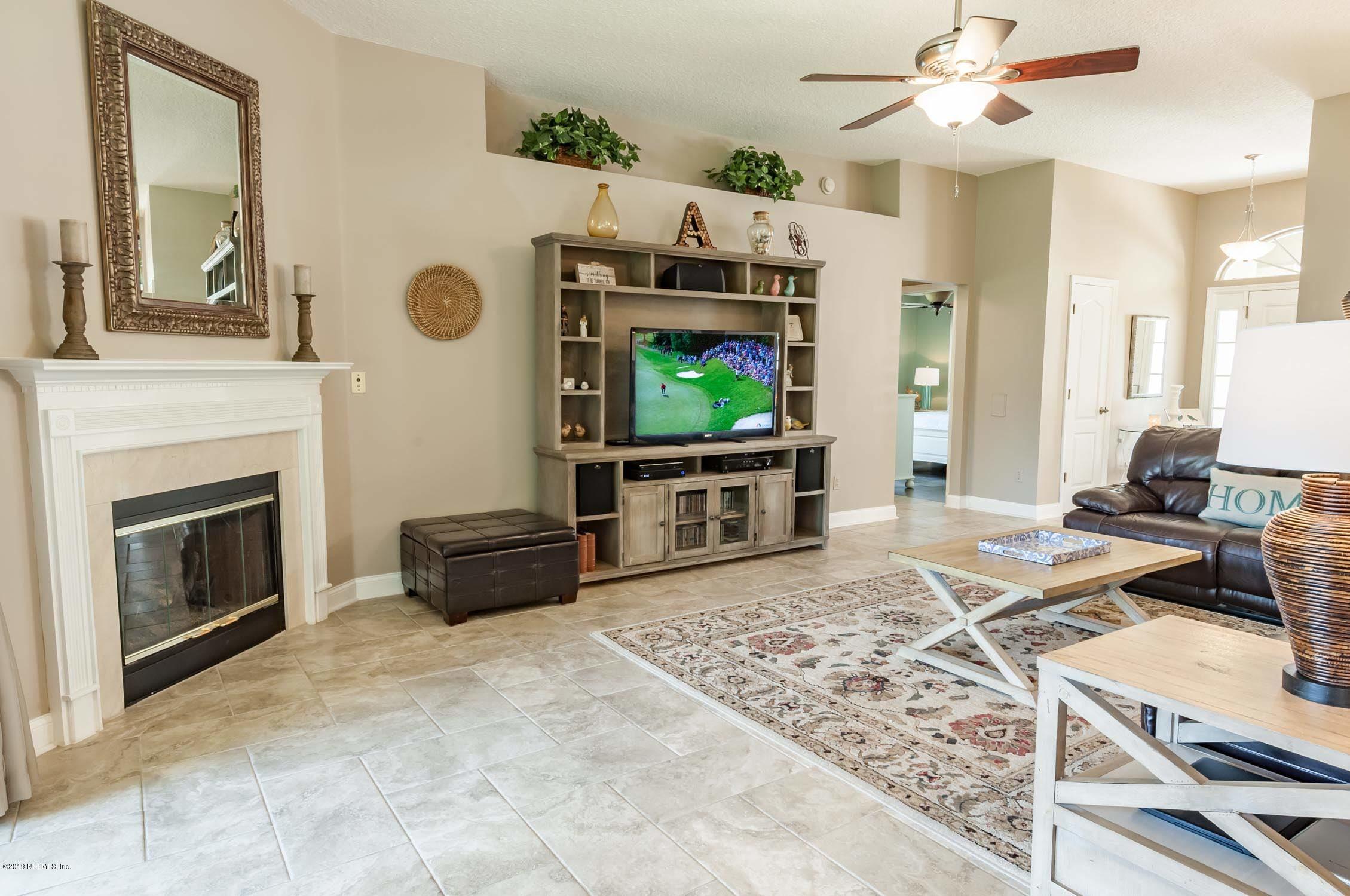 1152 Sandlake Road St. Augustine, FL 32092 - Photo 10 of 46 a living room with furniture a flat screen tv and a fireplace