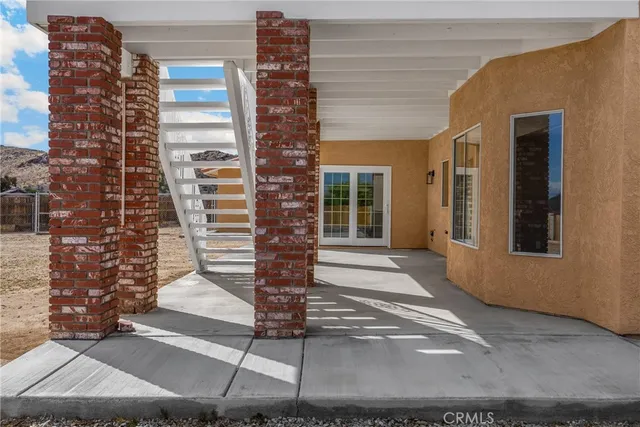 a view of a white house with a yard and potted plants