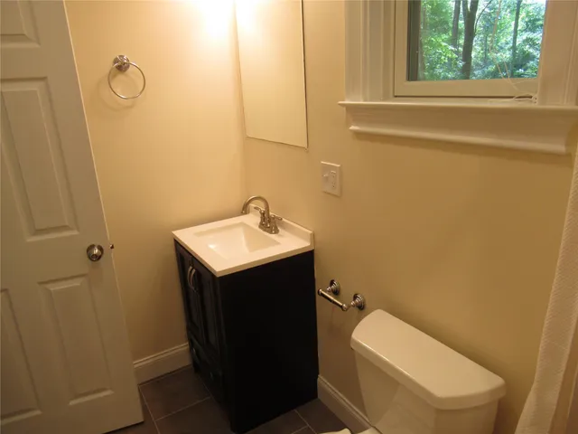 a bathroom with a toilet sink and mirror