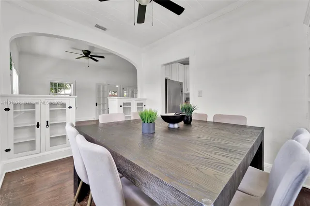 a view of a dining room and livingroom with furniture wooden floor a chandelier