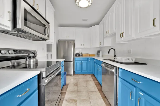 a kitchen with stainless steel appliances a stove sink and cabinets
