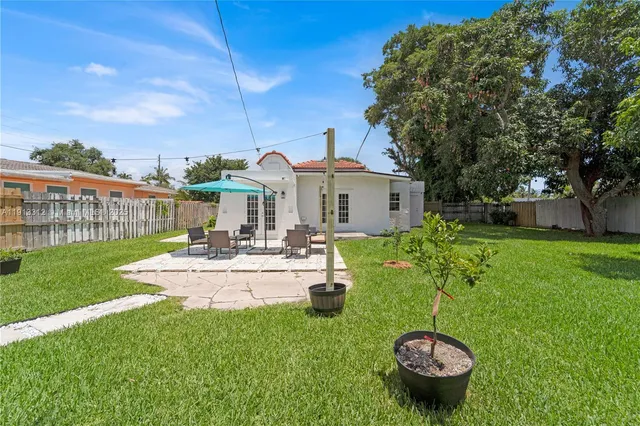 a view of a house with backyard outdoor seating and green space
