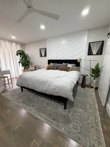 a bedroom with a large bed and potted plant