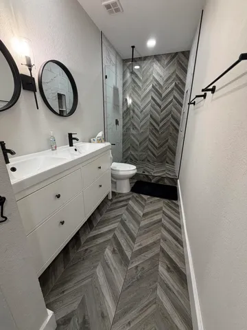 a bathroom with a double vanity sink mirror and toilet