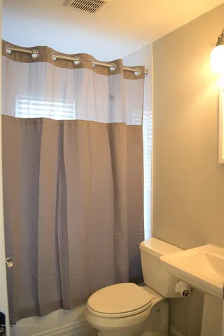 a bathroom with a toilet a sink and tub