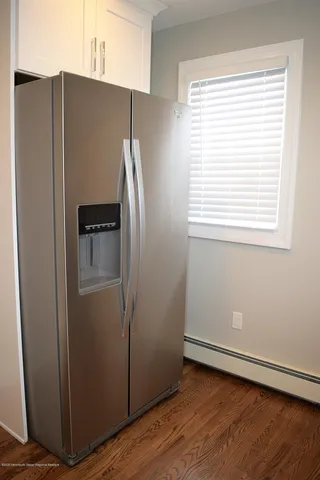 a view of a refrigerator in kitchen and wooden floor