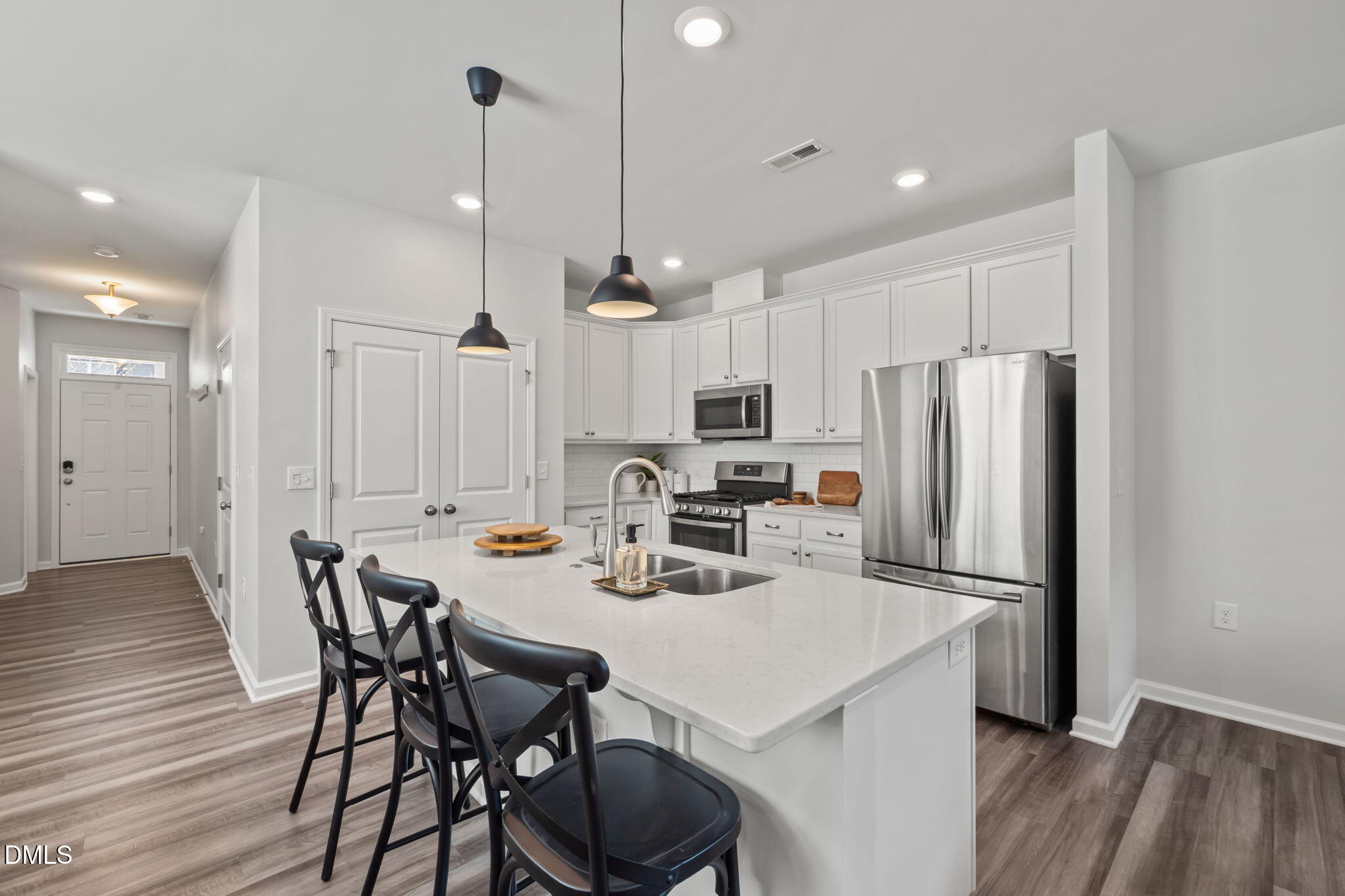1050 Gentle Reed Drive Durham, NC 27703 - Photo 7 of 37 a kitchen with a dining table chairs refrigerator and microwave