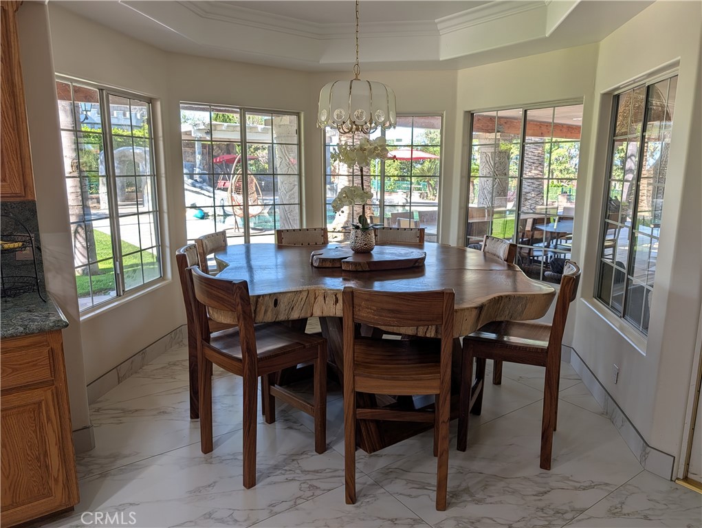1719 Crystal Ridge Court Riverside, CA 92506 - Photo 18 of 60 a dining room with furniture large windows and a chandelier