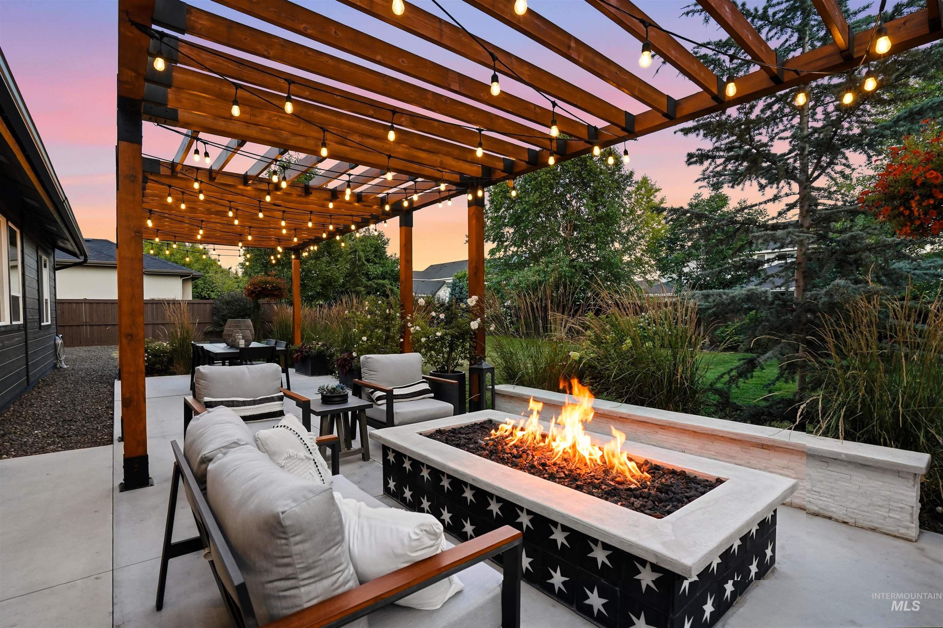4323 West Ladle Rpds Drive Meridian, ID 83646 - Photo 42 of 49 Outdoor patio featuring a custom wood pergola with string lighting, a built-in gas fire pit, and concrete hardscaping