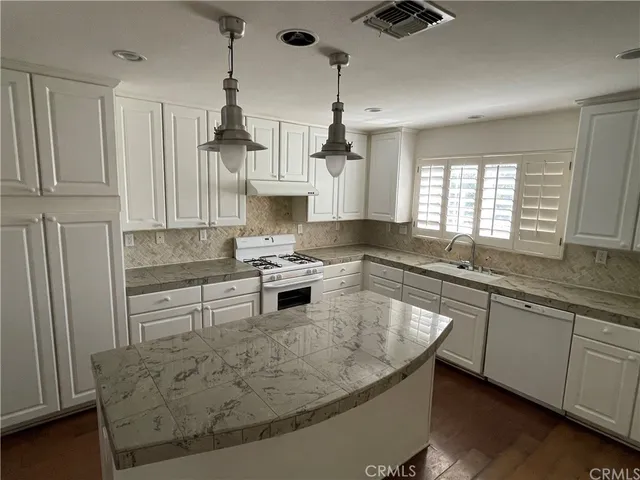 a kitchen with stainless steel appliances granite countertop a sink a stove and a granite counter tops