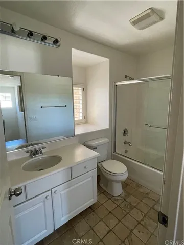 a bathroom with a granite countertop sink toilet a mirror and shower