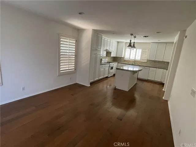 a kitchen with a sink dishwasher refrigerator stove and white cabinets