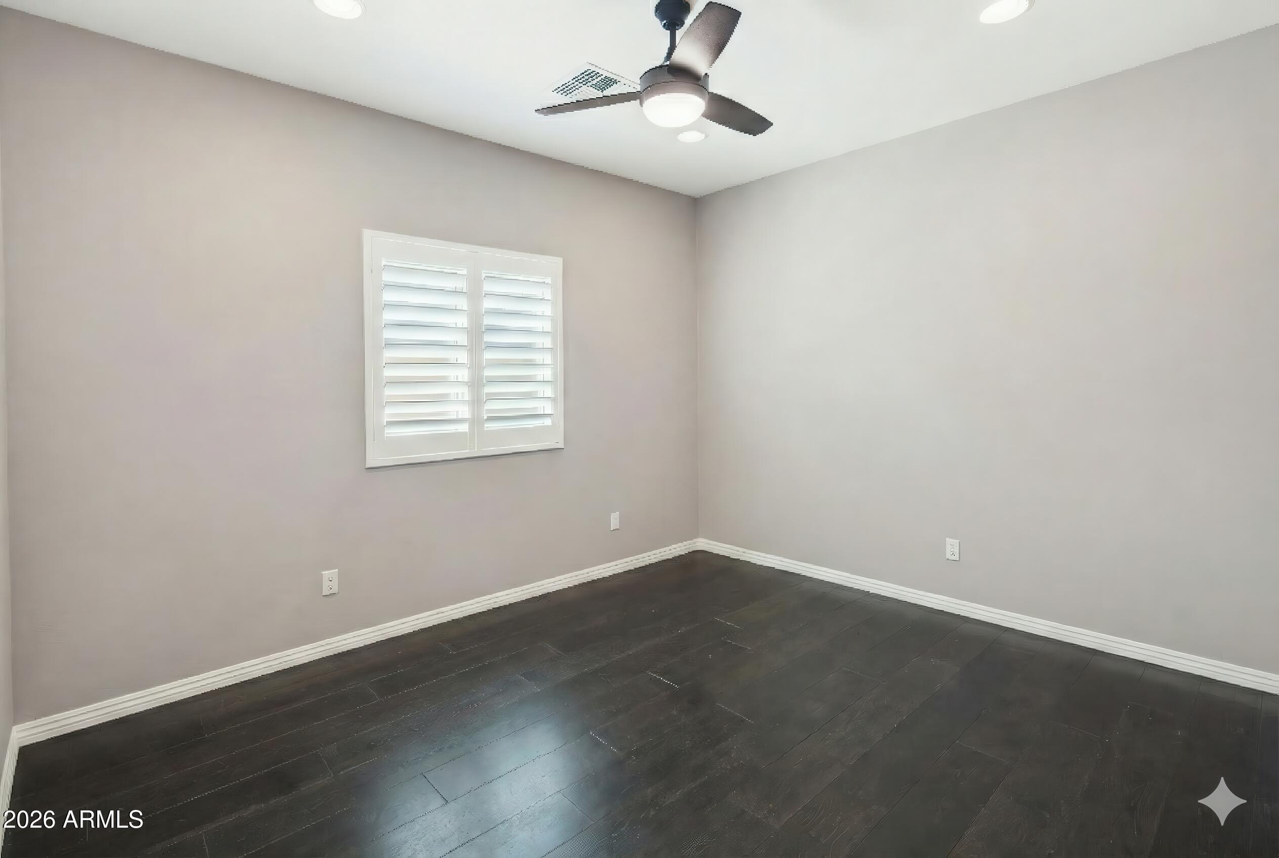 10772 West Yearling Road Peoria, AZ 85383 - Photo 23 of 39 an empty room with wooden floor ceiling fan and windows