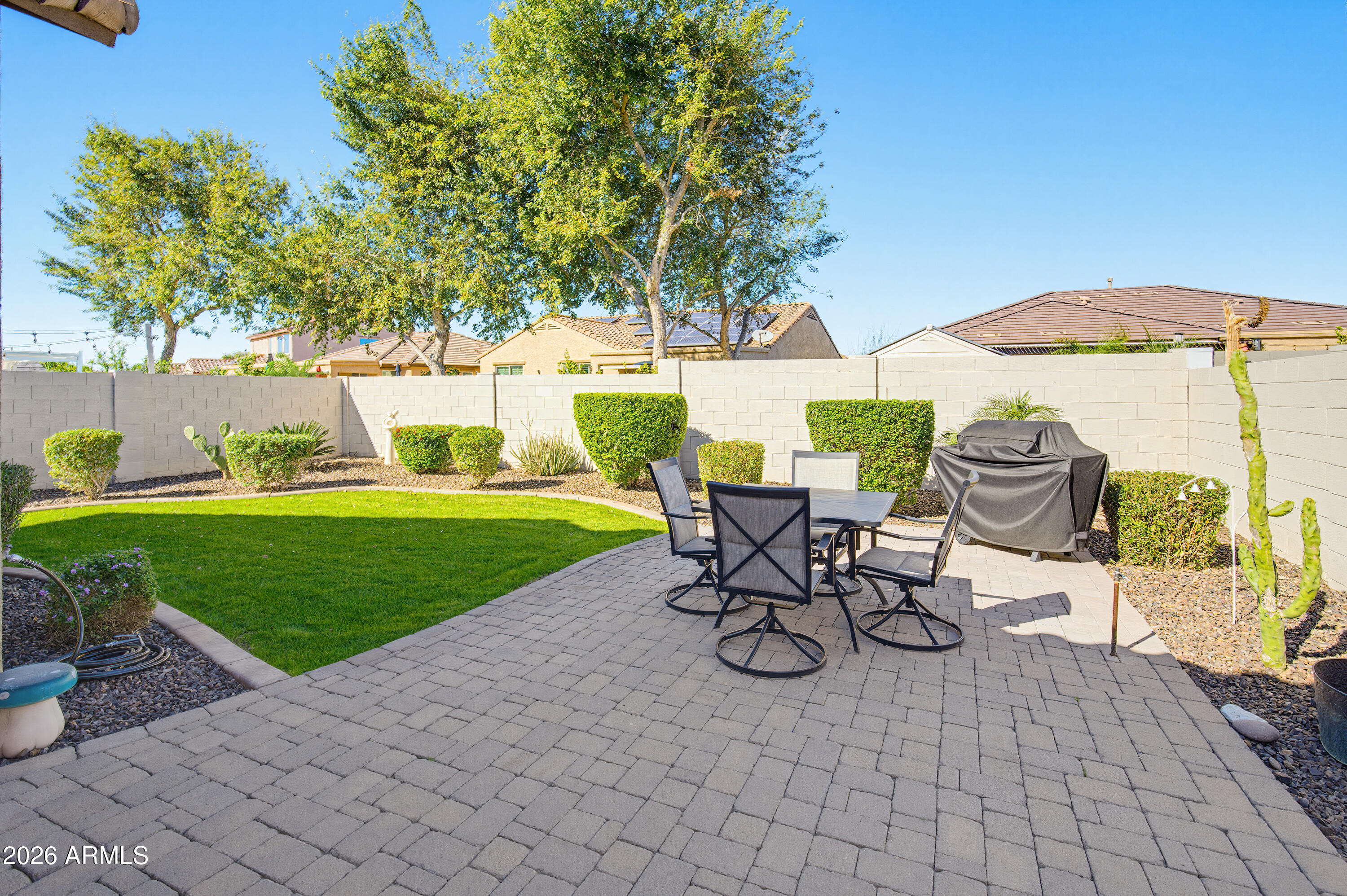 10772 West Yearling Road Peoria, AZ 85383 - Photo 30 of 39 a view of a table and chairs in backyard under a large tree