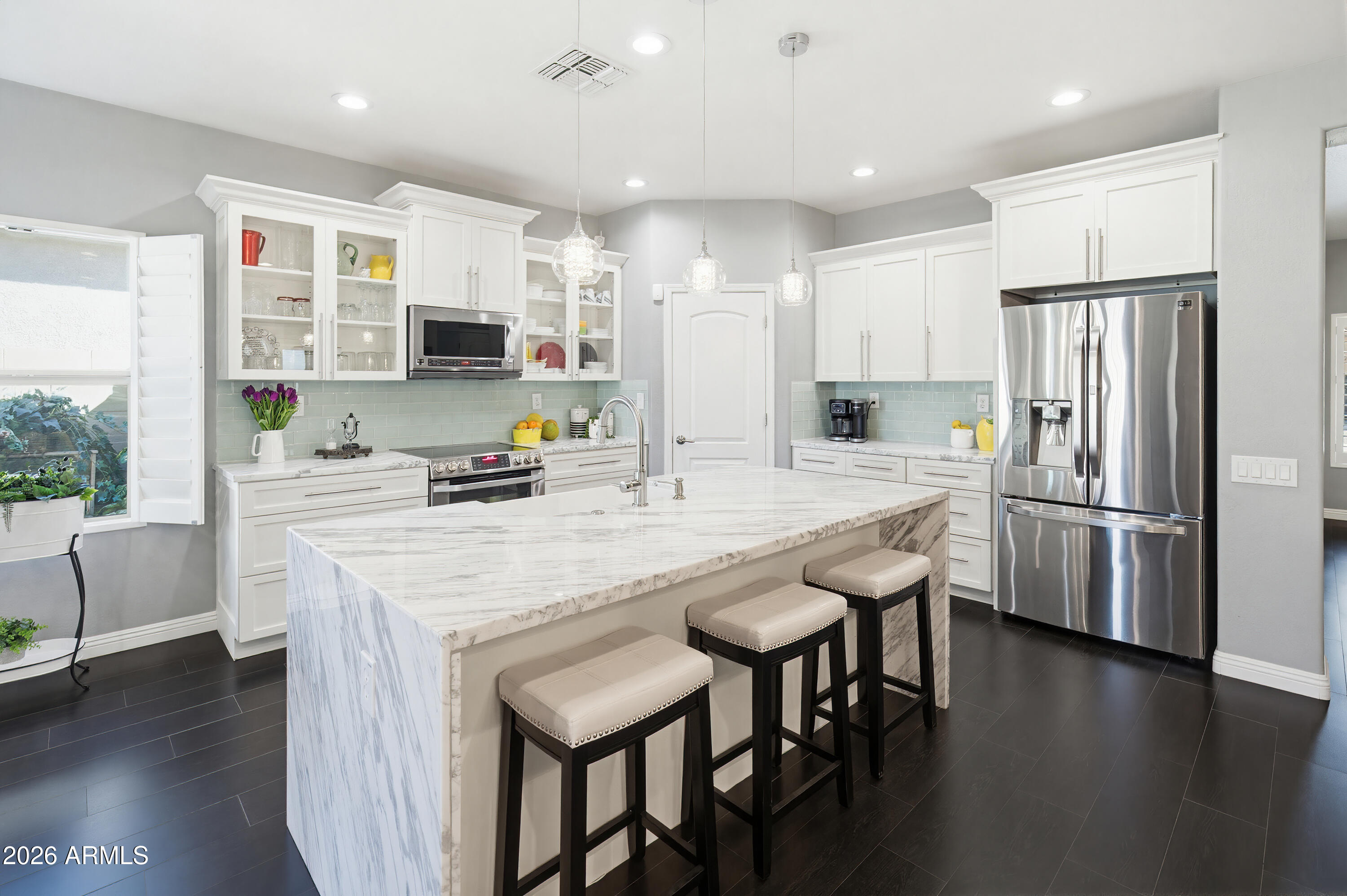 10772 West Yearling Road Peoria, AZ 85383 - Photo 3 of 39 a kitchen with stainless steel appliances granite countertop a table chairs refrigerator a sink dishwasher and a stove with wooden floor