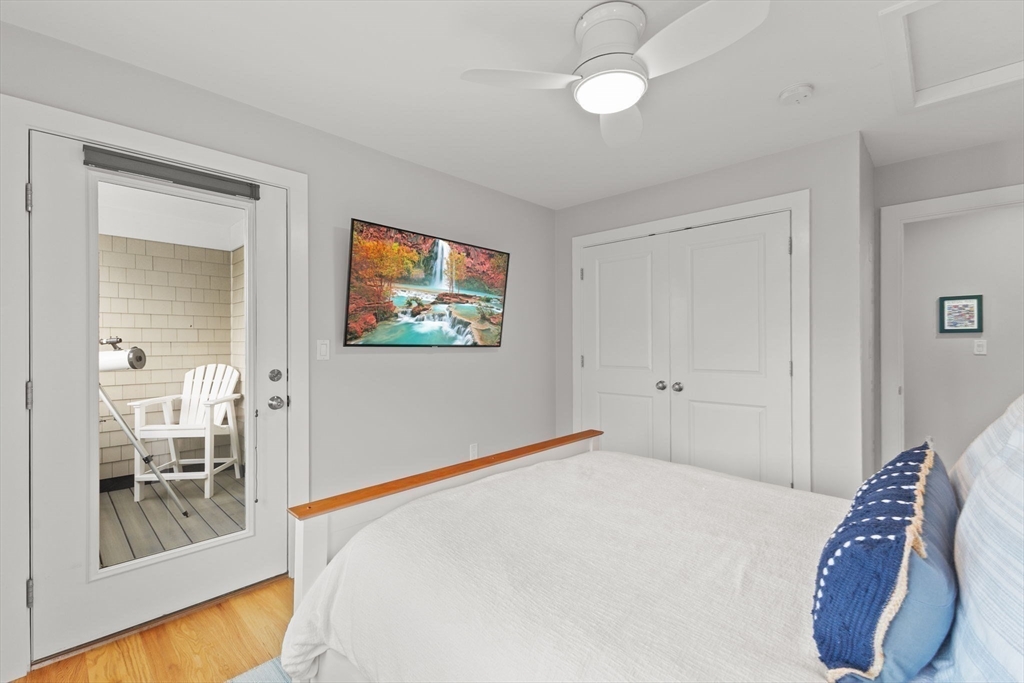 15 Buttonwood Lane Scituate, MA 02066 - Photo 28 of 42 a bedroom with a large bed and a chandelier