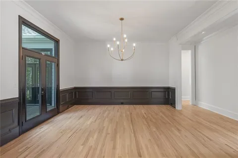 an empty room with windows fireplace and wooden floor
