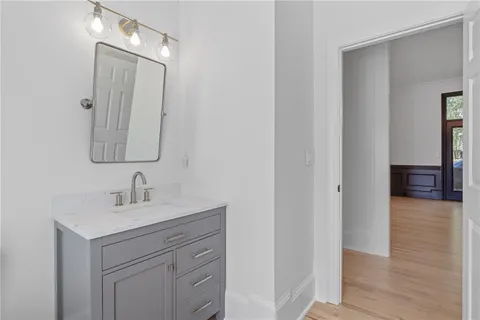 a spacious bathroom with double vanity a mirror a window and a bathtub