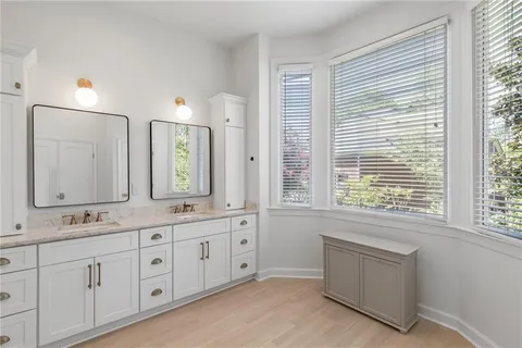 an empty room with wooden floor chandelier fan and windows