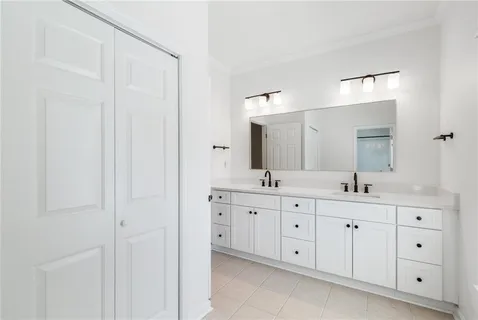 an empty room with wooden floor a ceiling fan and kitchen view
