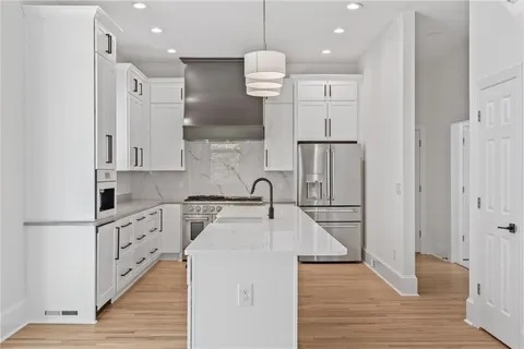 a kitchen with stainless steel appliances a sink a stove and a refrigerator